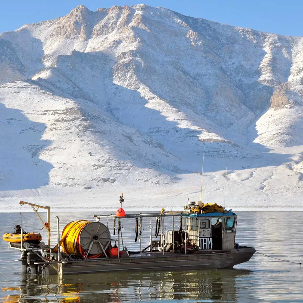 Barco cosechador con montañas nevadas